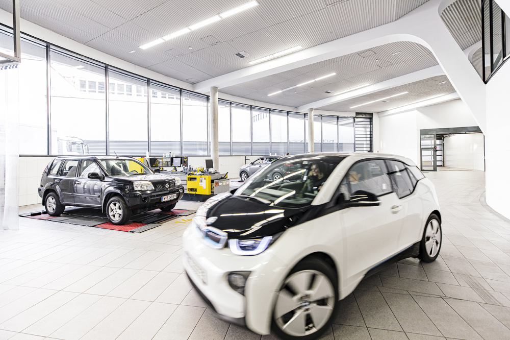 Fahrzeuge bei technischer Prüfung in heller Kfz-Halle.